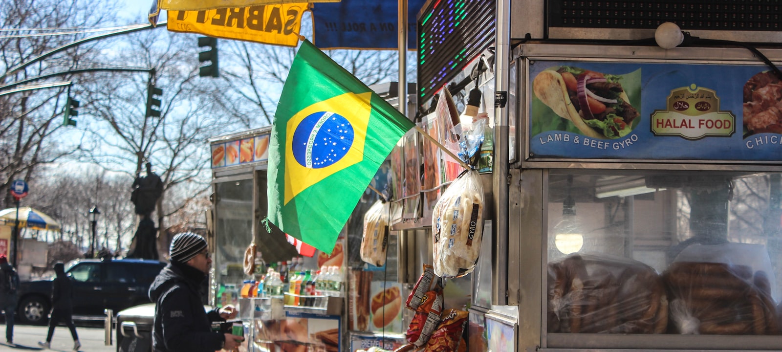 An independent street food vendor serving customers from a mobile cart